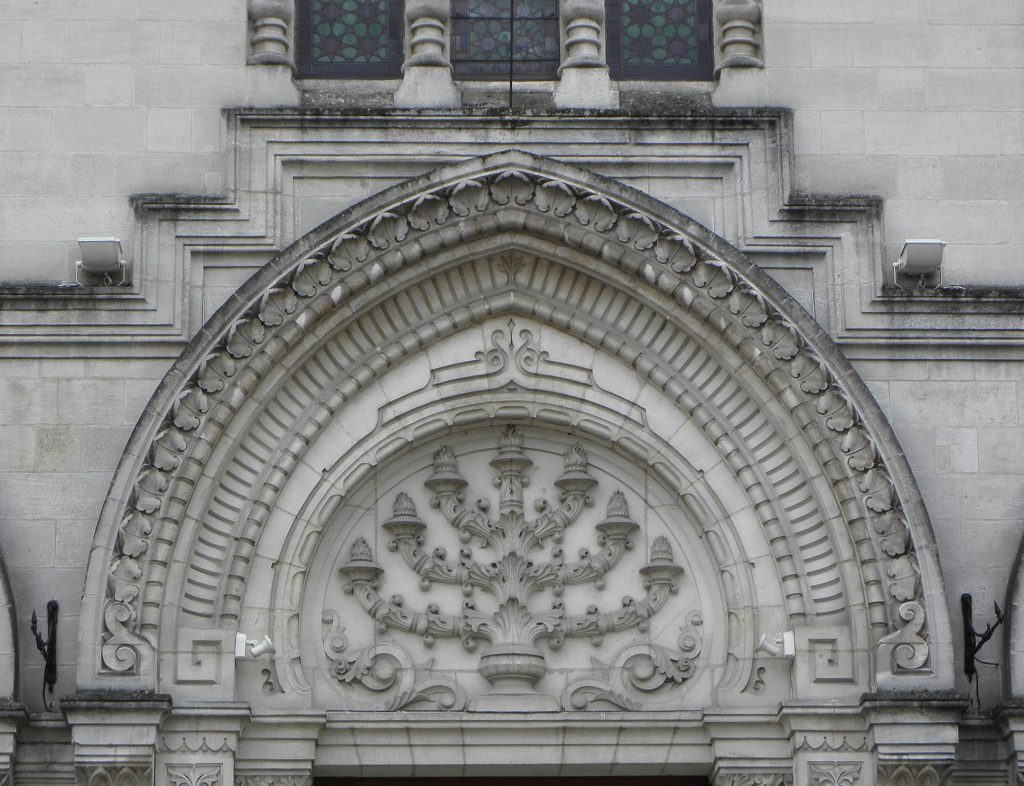 Vue extérieure de l'entrée de la synagogue de Bordeaux avec une menorah sculptée