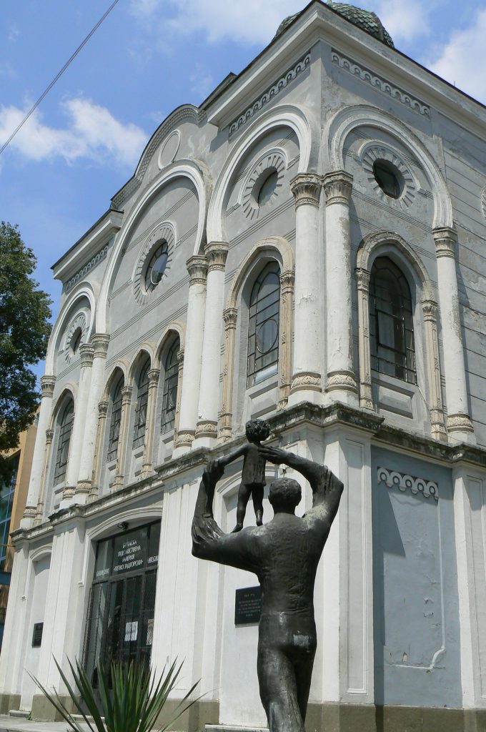 Statue d'un homme portant un enfant devant l'immeuble de la synagogue de Burgas