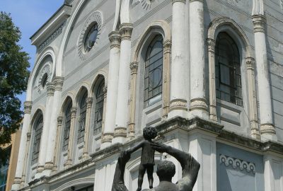 Statue of a man and a child in front of the synagogue of Burgas