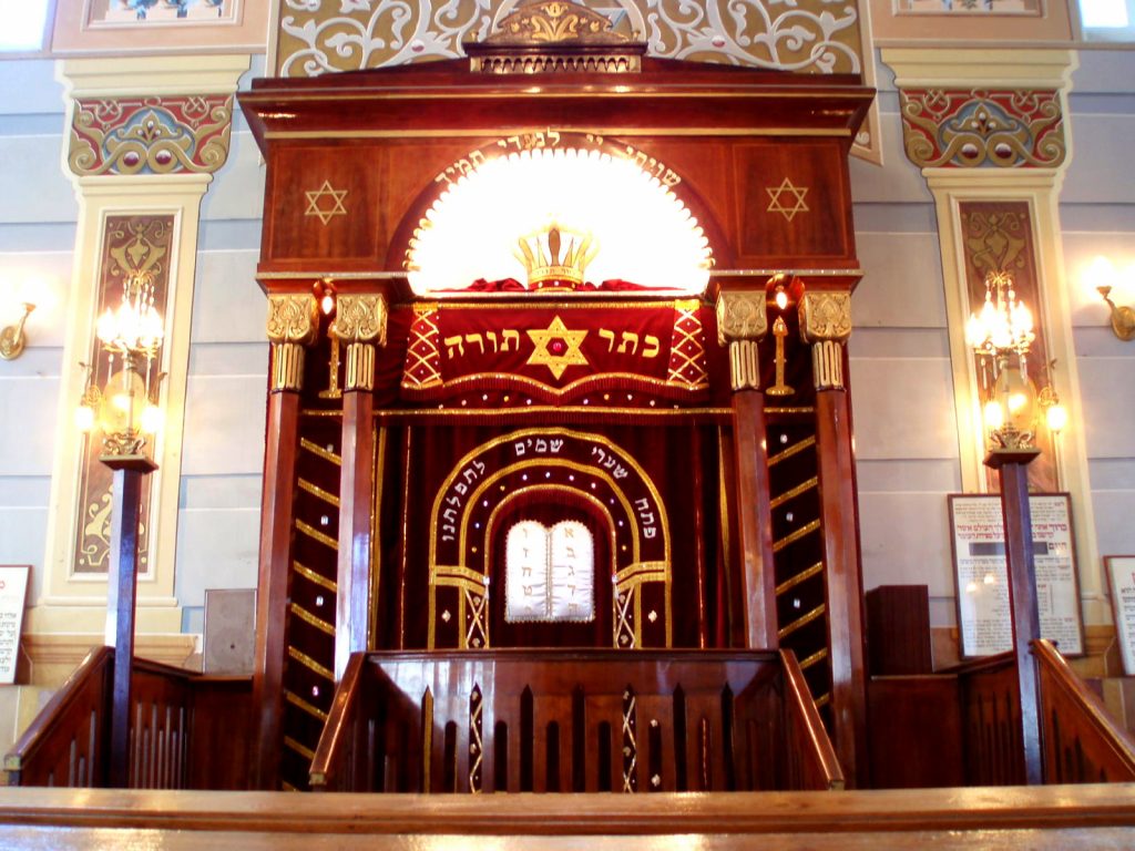 Interior of the Tbilisi synagogue with red curtains covering the Torah